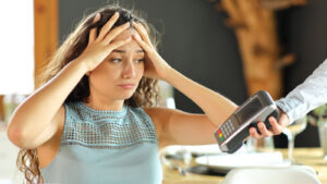 woman stressed over bill tip at restaurant